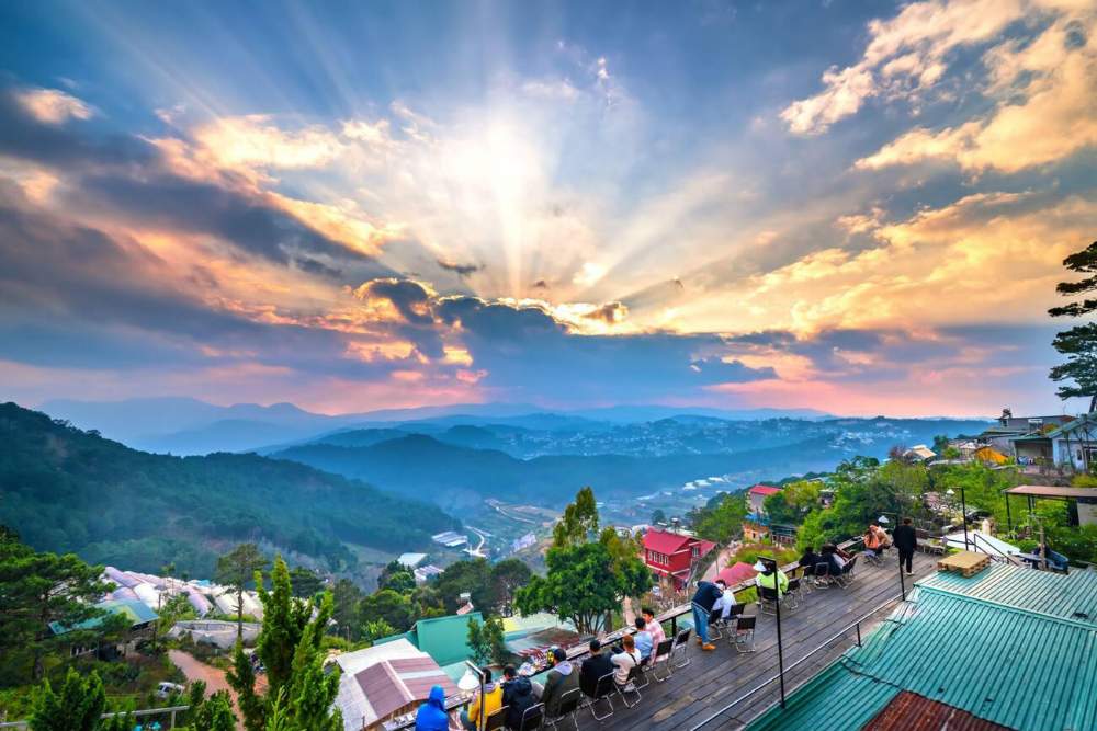 תיירים צופים בזריחה בבית קפה עם נוף לעמק בדה לאט.